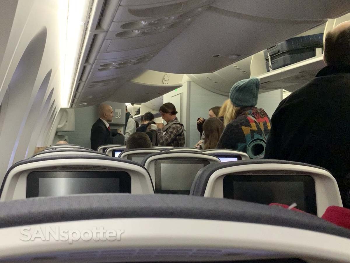 Air Canada 787-9 economy passengers retrieving luggage after the flight