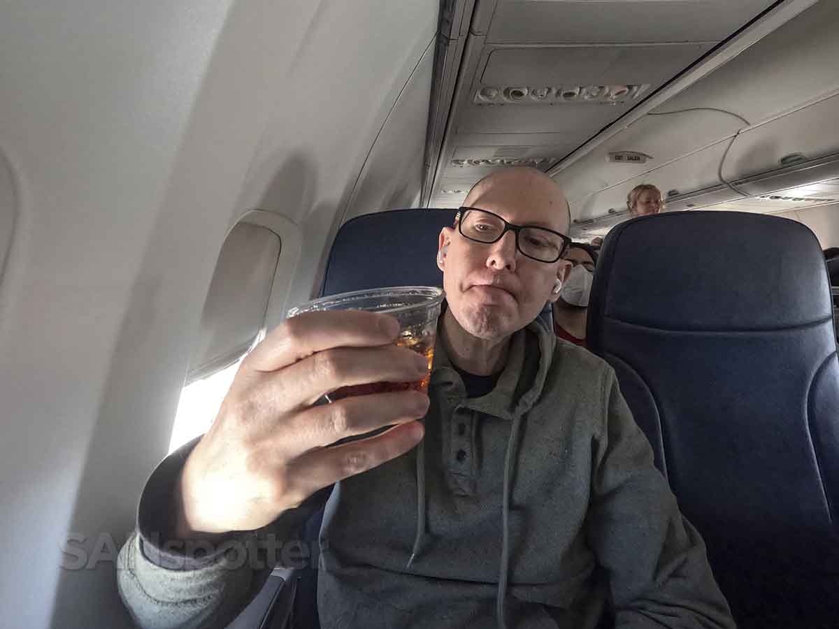 SANspotter drinking Diet Coke in a sun country airlines standard seat