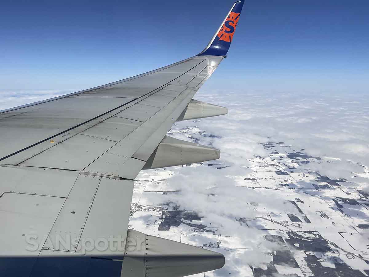 Sun Country 737-800 wing flying over snowy Minnesota 