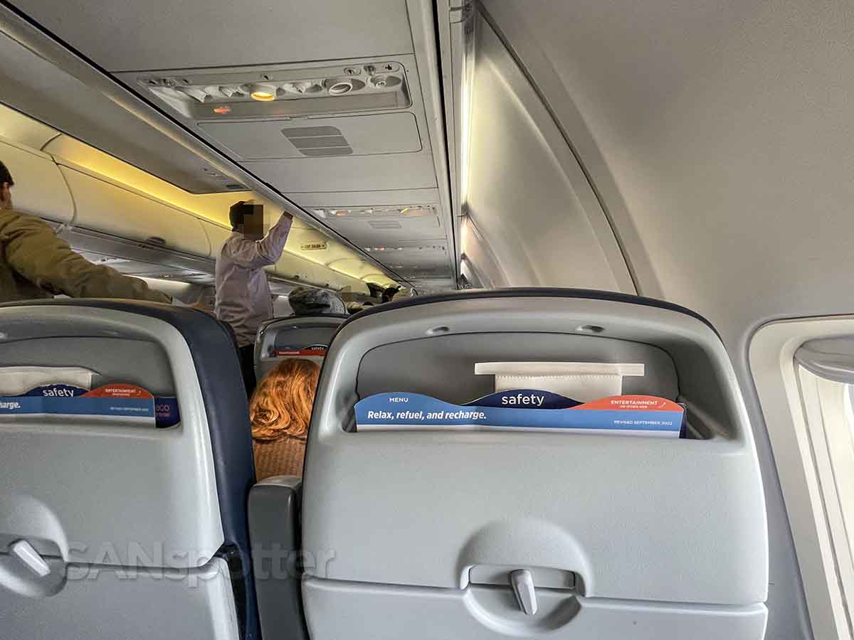 Sun Country 737-800 passengers retrieving bags from overhead bin