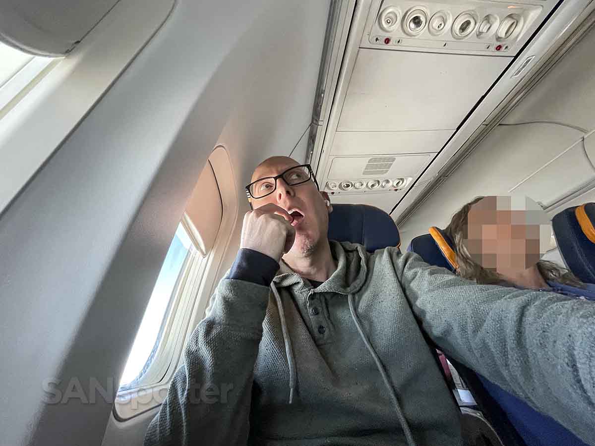 SANspotter eating a snack in a sun country airlines best seat