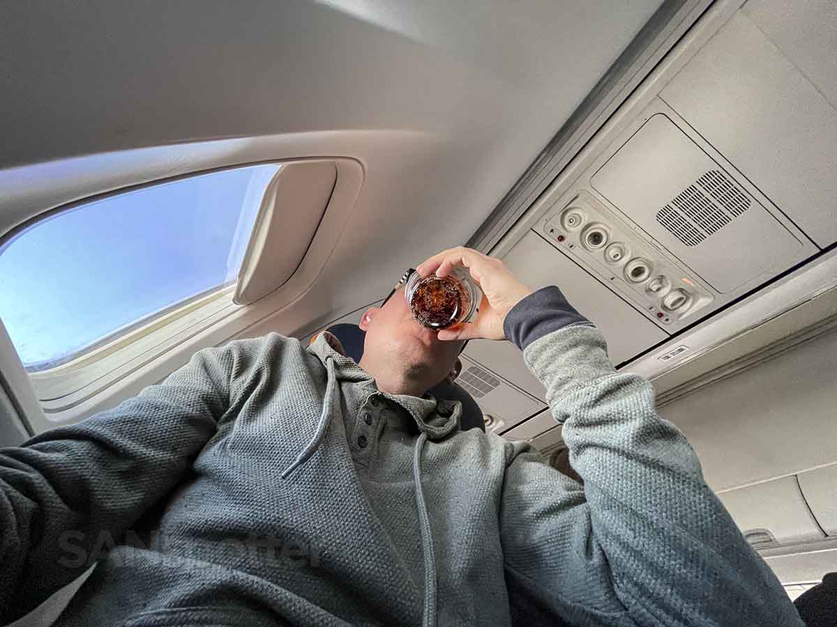 SANspotter drinking a Diet Coke in a sun country airlines best seat