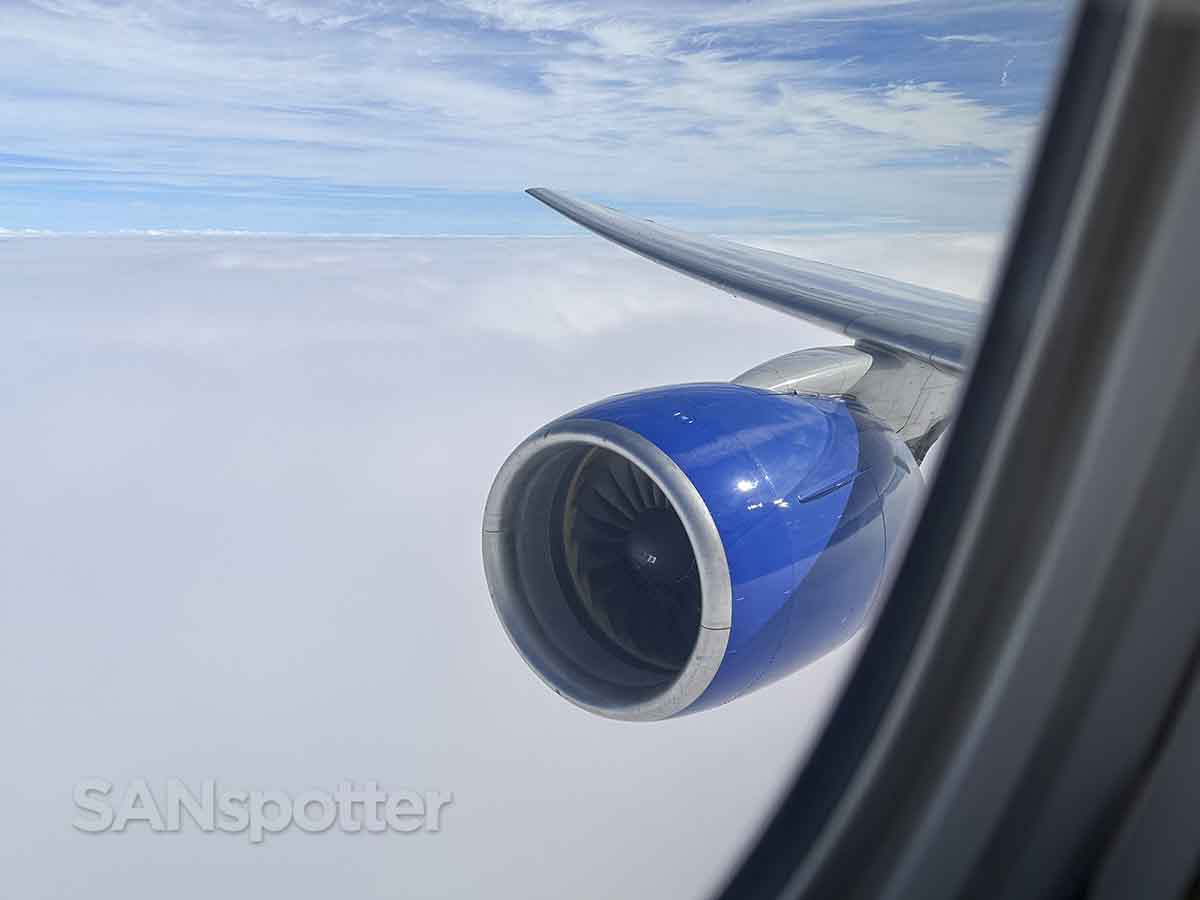 United 777–200 climbing above the clouds