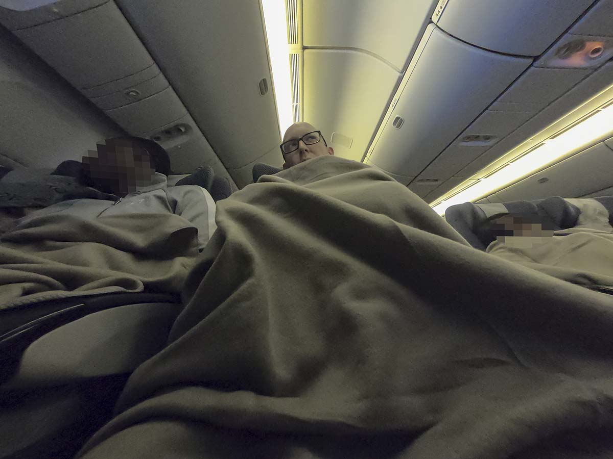 Scott Leazenby sleeping in British Airways 777-300ER economy