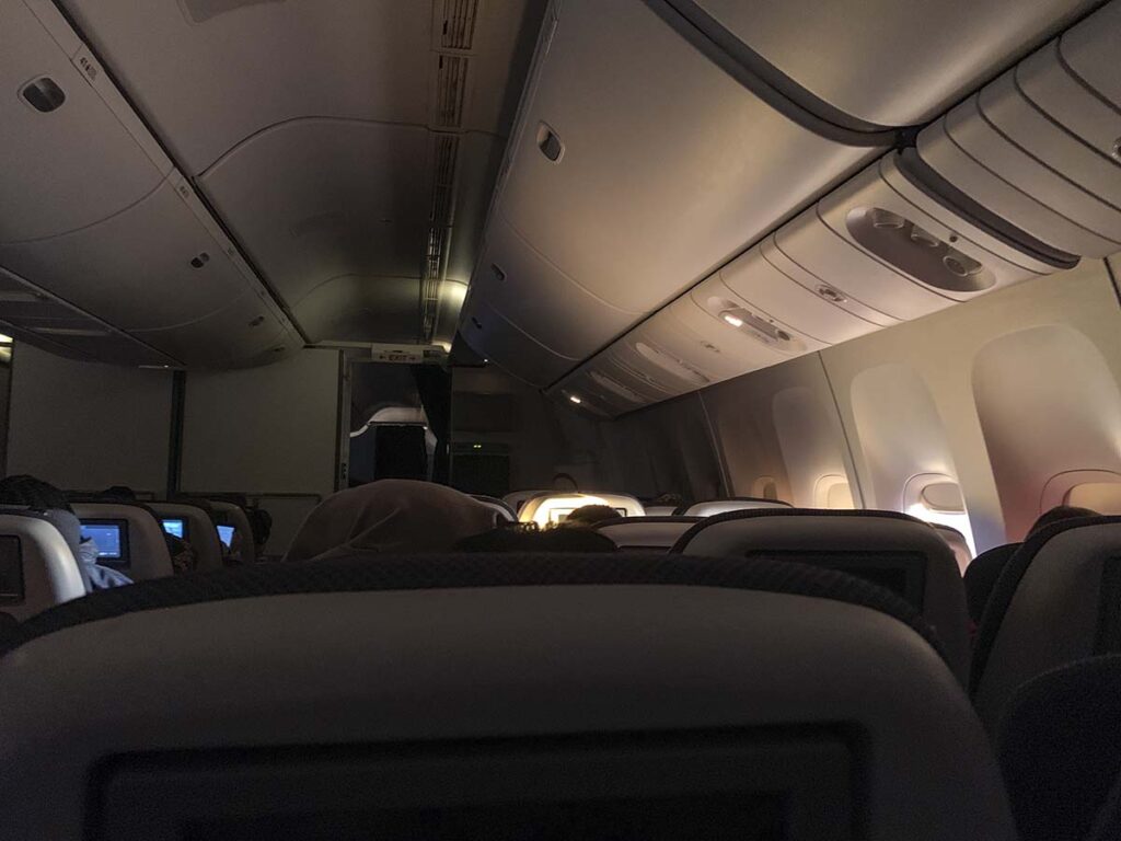 British Airways 777-300ER economy open window shades on nighttime flight
