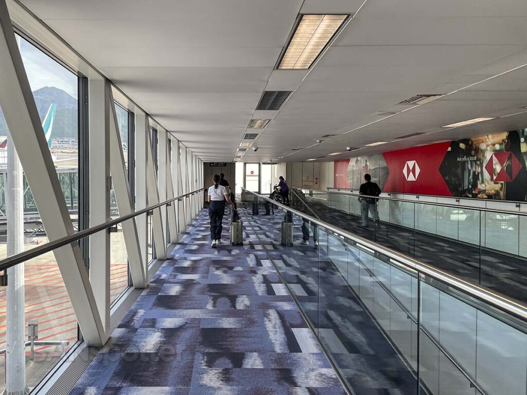 Walking down the jetway to board a flight just after having my boarding pass stand at the gate 65 HKG
