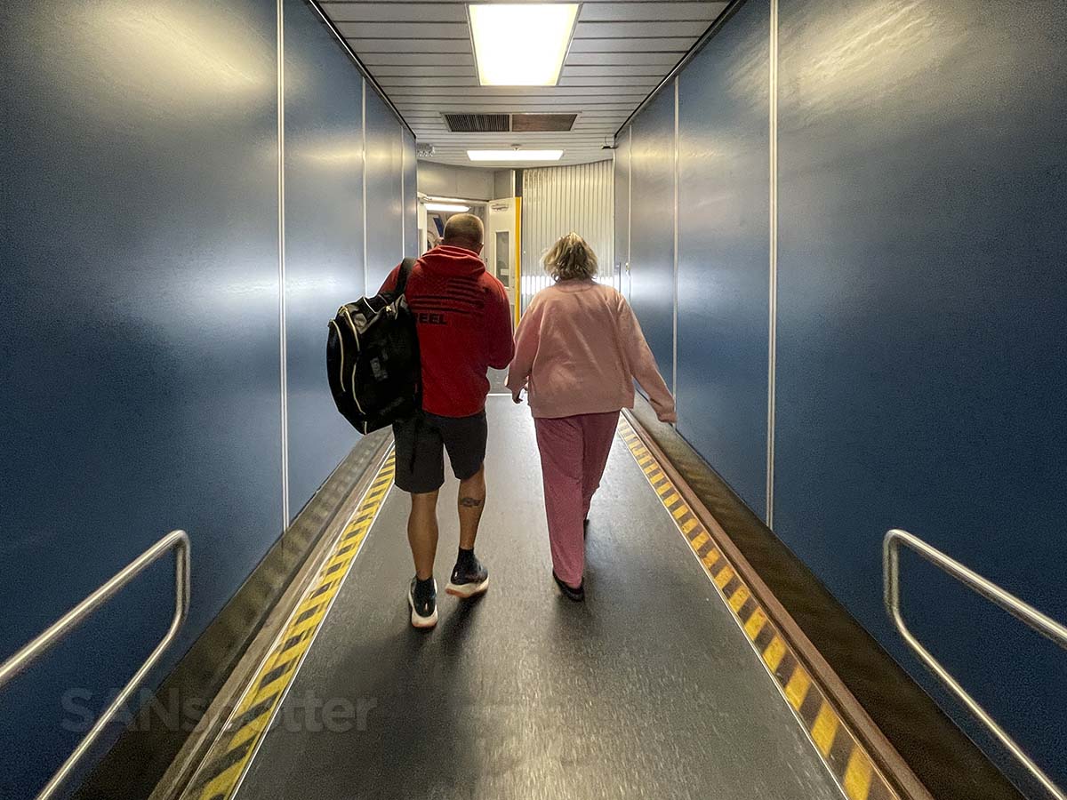 Passengers walking down gate 77 jet bridge terminal 7 LAX