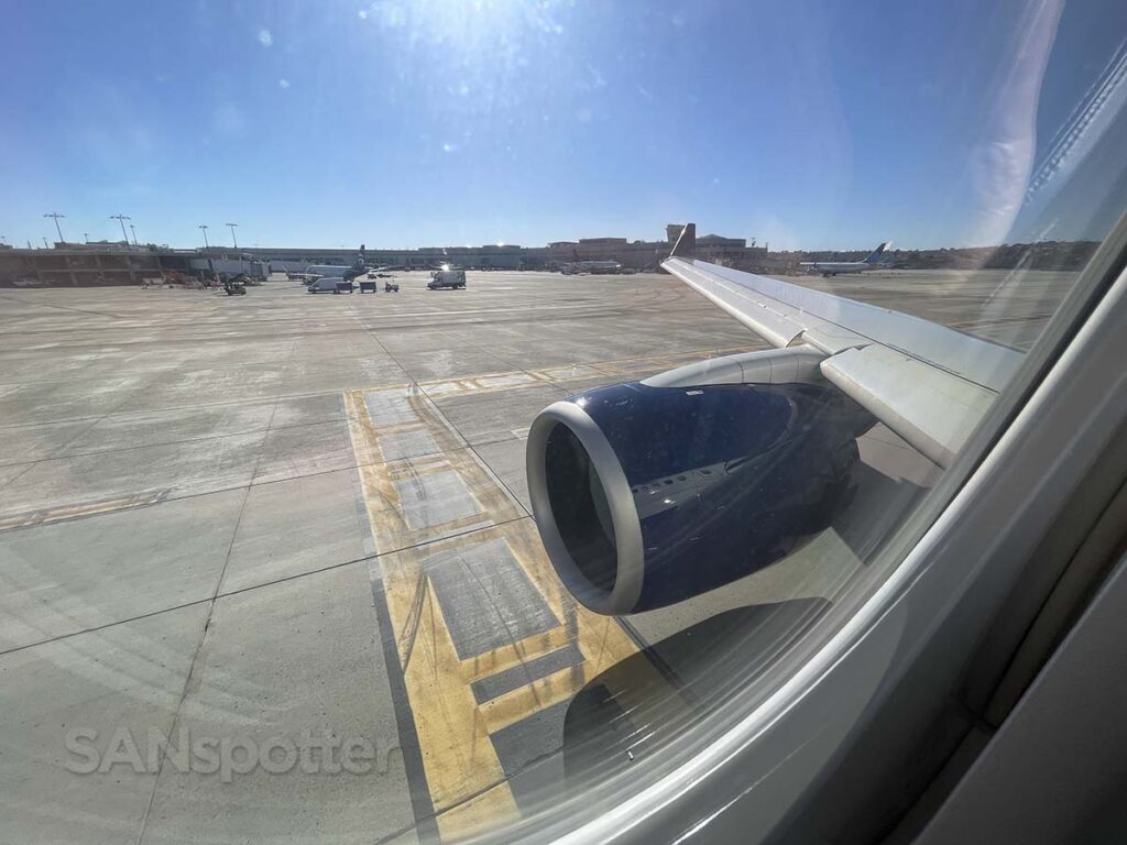 Window view of the engine and wing of a Delta A220-100 while taxiing at San Diego airport