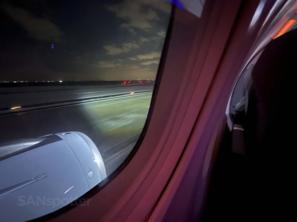 View from the window of seat 13A in American Airlines A321XLR premium economy as we taxi to the gate at JFK at night