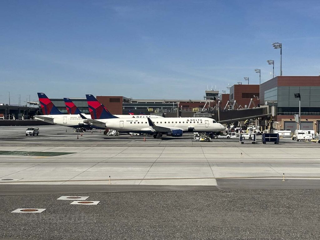 Taxiing by Delta aircraft parked at the gate at the Salt Lake City International Airport