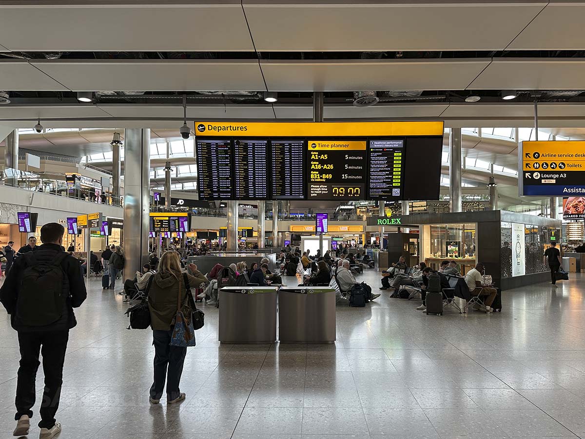 Passengers looking at the departures board inside terminal 2 at Heathrow airport