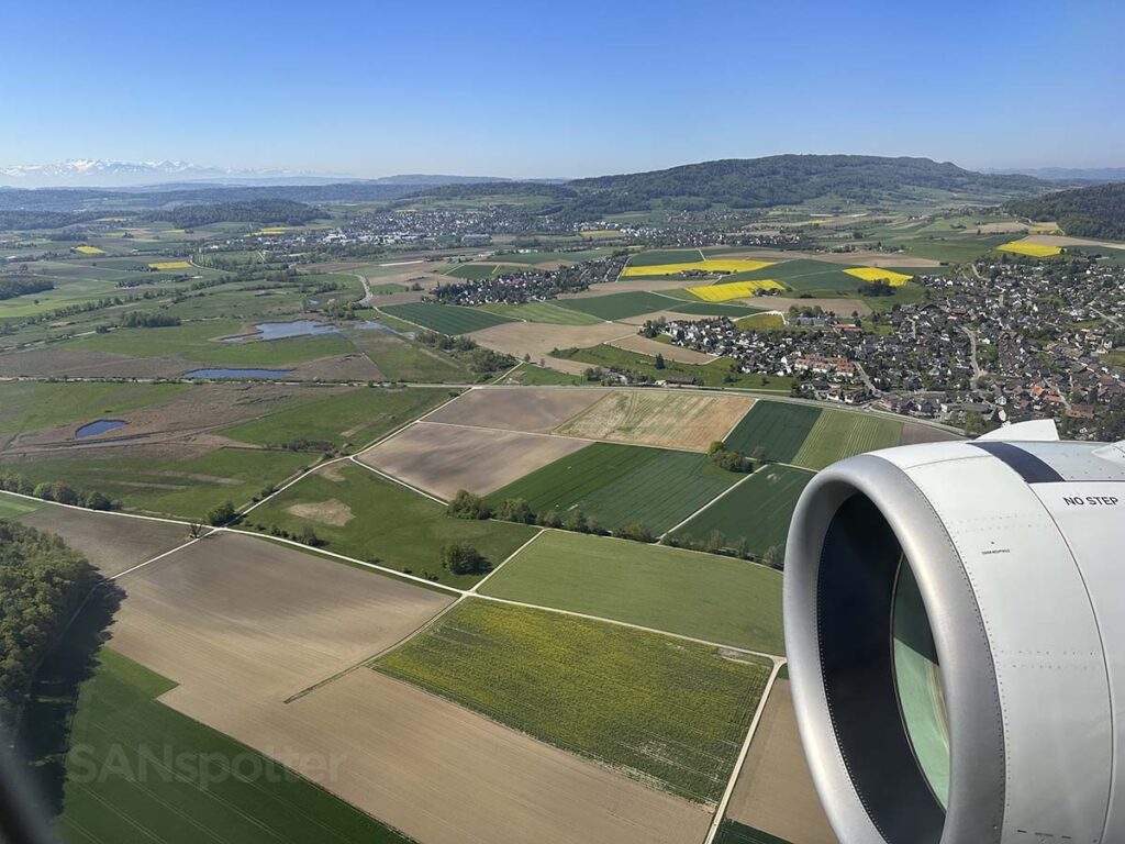 Swiss A320neo approaching Zürich Airport over lush green farmland