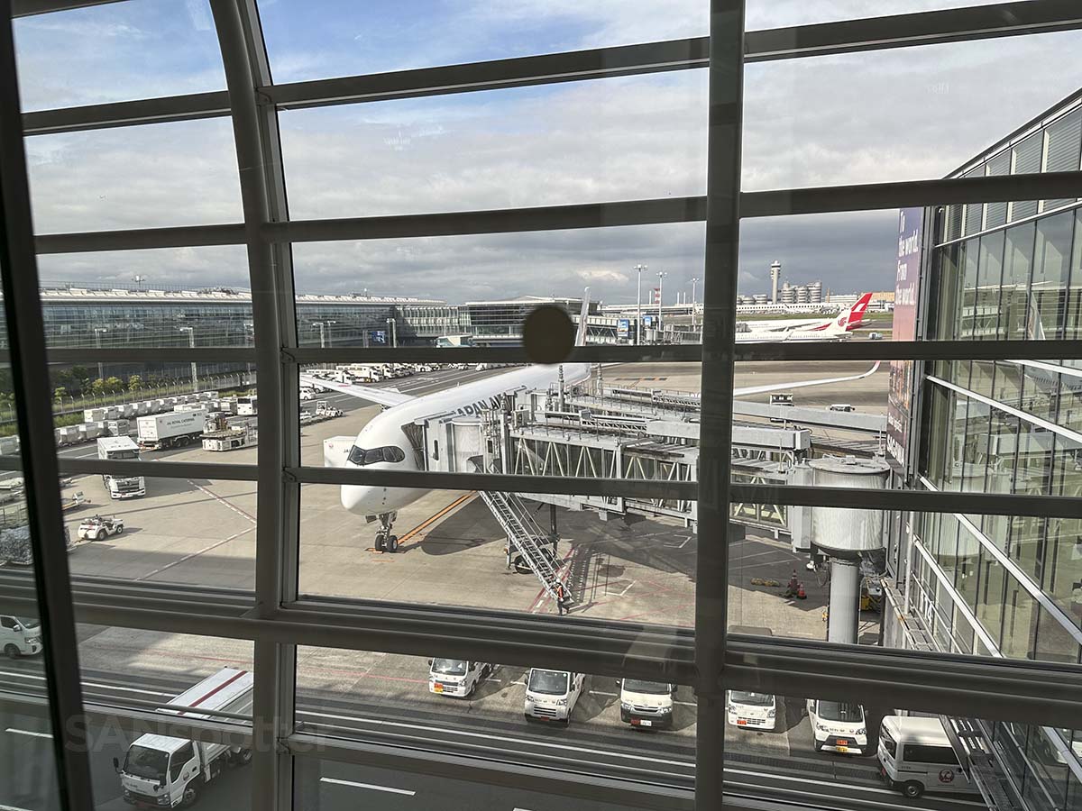 Looking at a JAL A350-1000 through the windows of gate 114 terminal 3 Tokyo Haneda airport