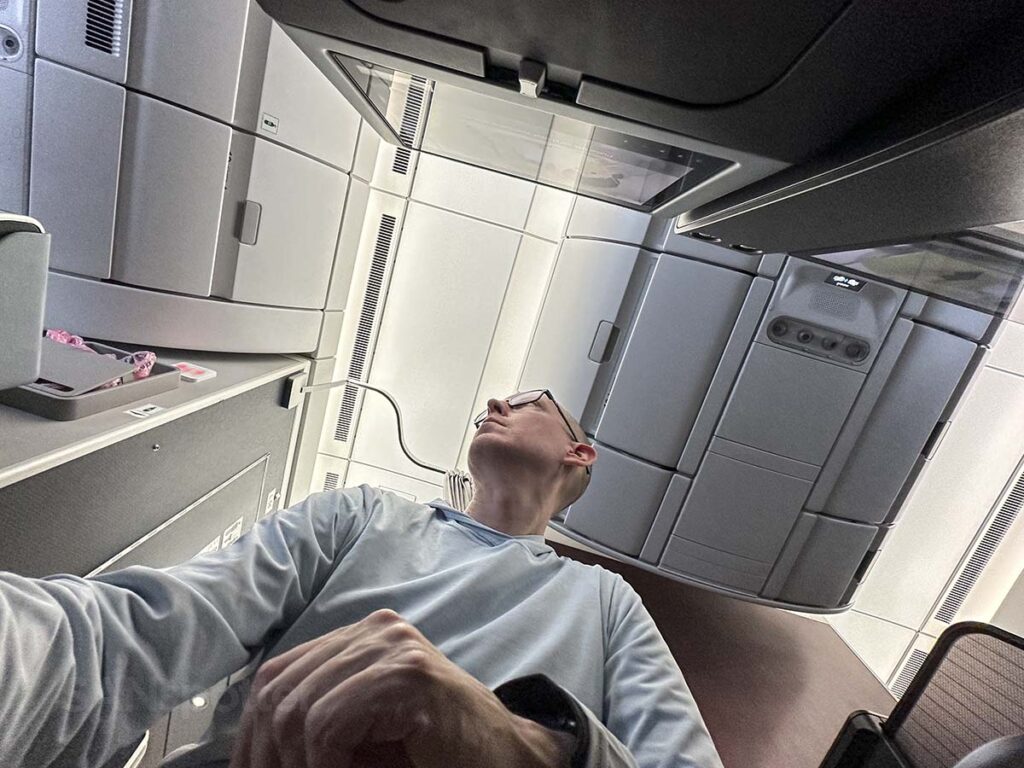 Scott trying to look out the window from the middle section in JAL A350-1000 premium economy