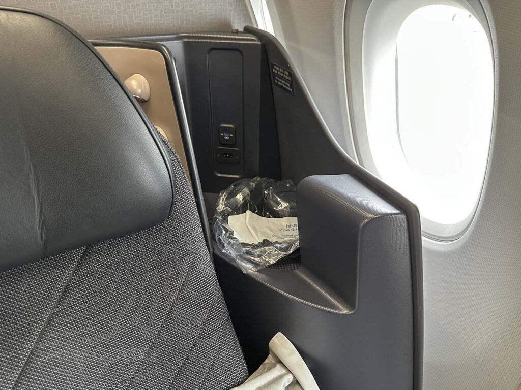 Korean Air A321neo business class USB charging ports and audio jack located just over the shoulder behind the seat