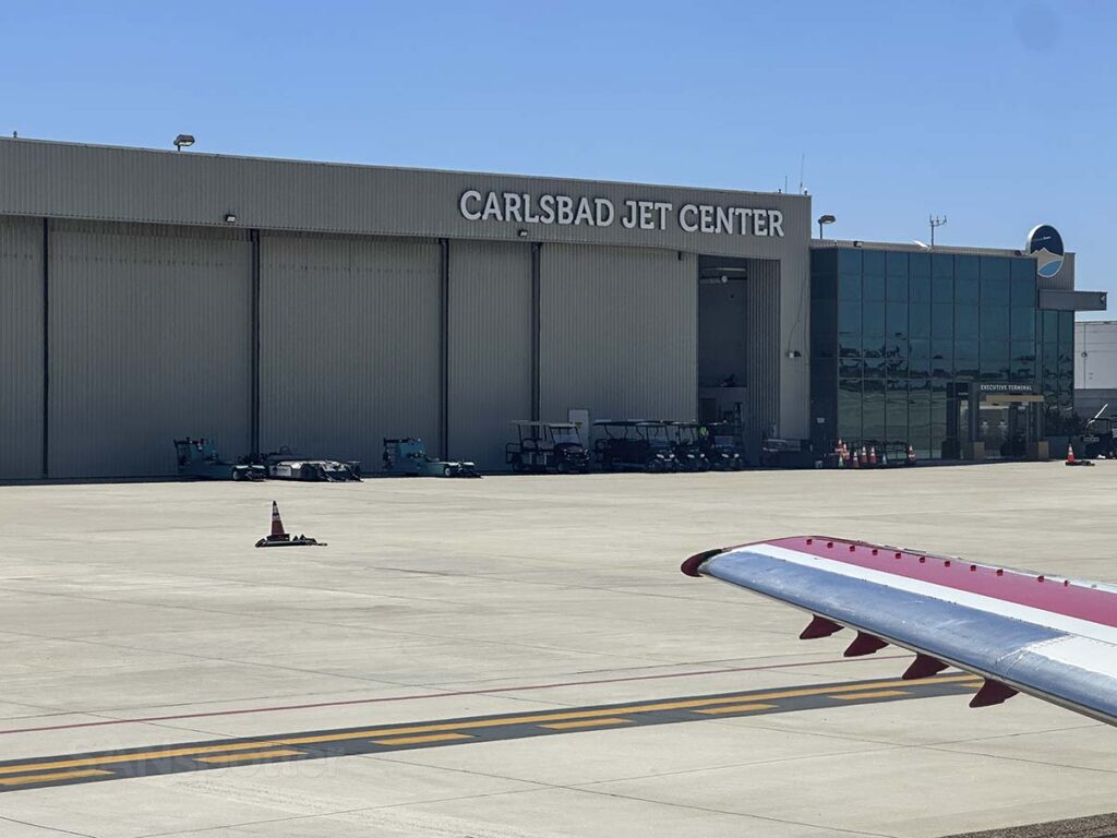 JSX Embraer 145 a taxi past the Carlsbad Jet Center at the McClellan-Palomar Airport