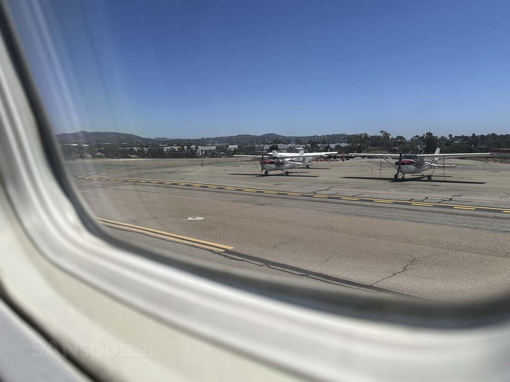 Looking at small aircraft from the window of a JSX E145 while taxing out to the runway at the McClellan-Palomar Airport