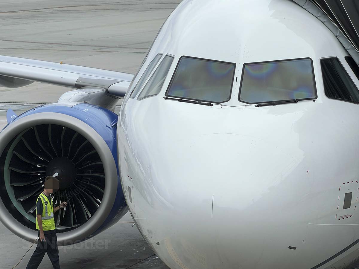Close-up of a ramp worker and the nose of a united Airlines A321XLR parked at gate 45 San Diego airport