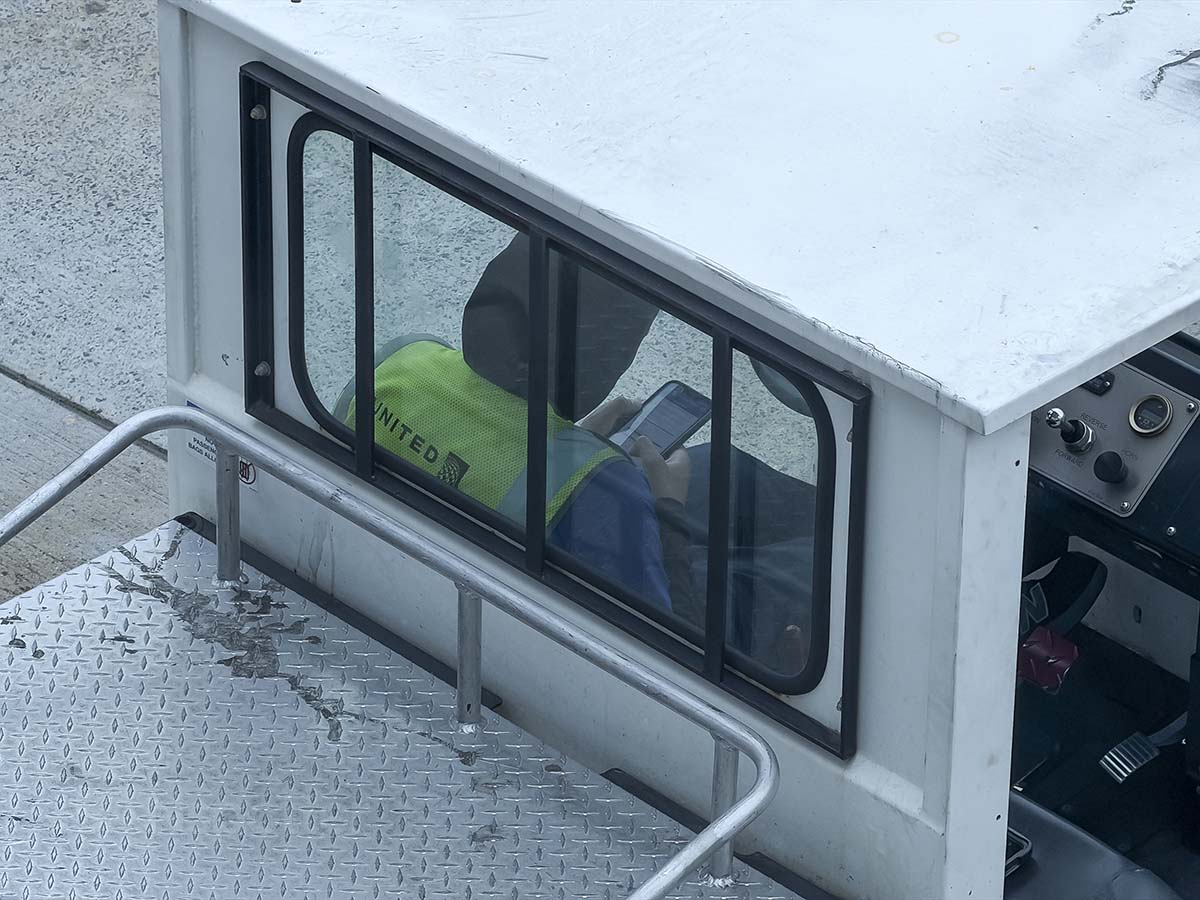 Close-up of a ramp worker driving a tug at the San Diego International Airport