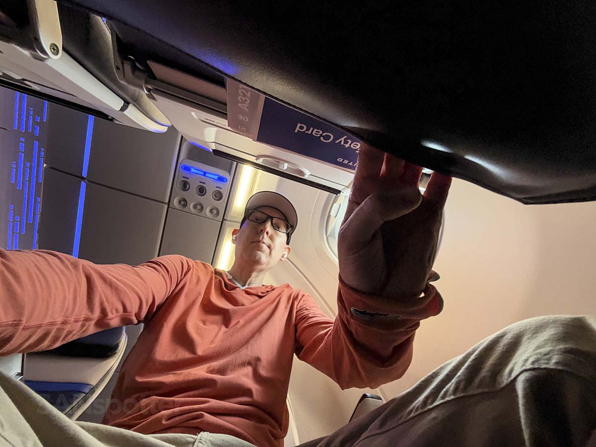 Scott Leazenby digging through the seat back pocket in front of him in United Airlines A321XLR economy