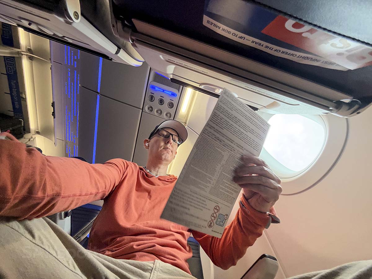 Scott Leazenby reading the safety card in United Airlines A321XLR economy
