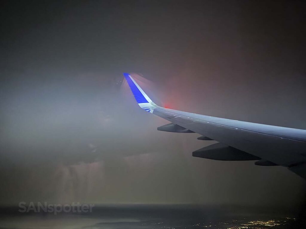 Looking out the window at the wing and winglet of a United Airlines A321XLR while on approach into IAD at night