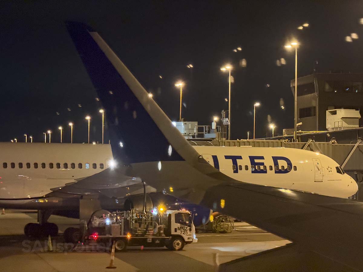 Looking out the window at the winglet of a United Airlines A321XLR while pulling up to gate D5 at IAD at night